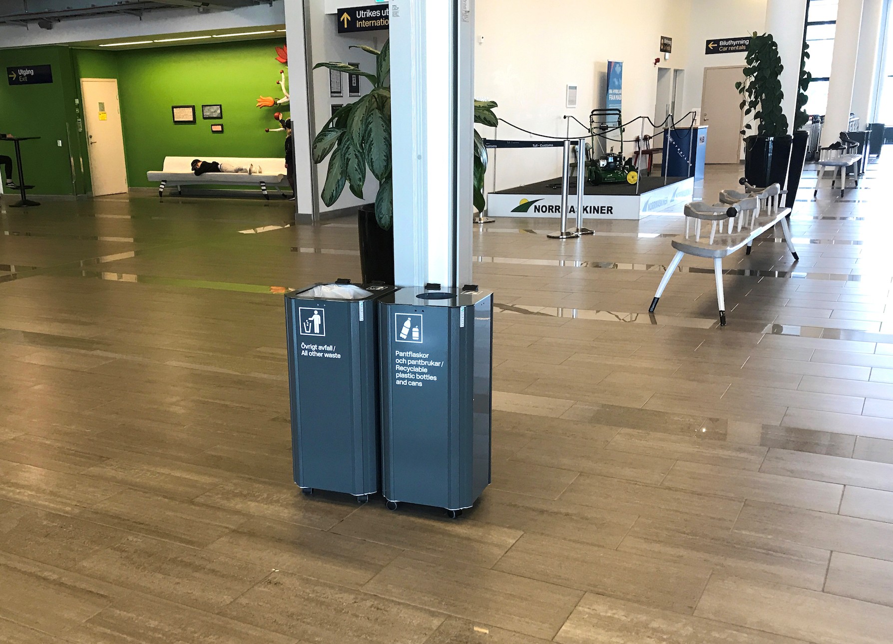 Två mörkgråa Sortify Kiwi kärl i en ljus terminalmiljö på Umeå Airport