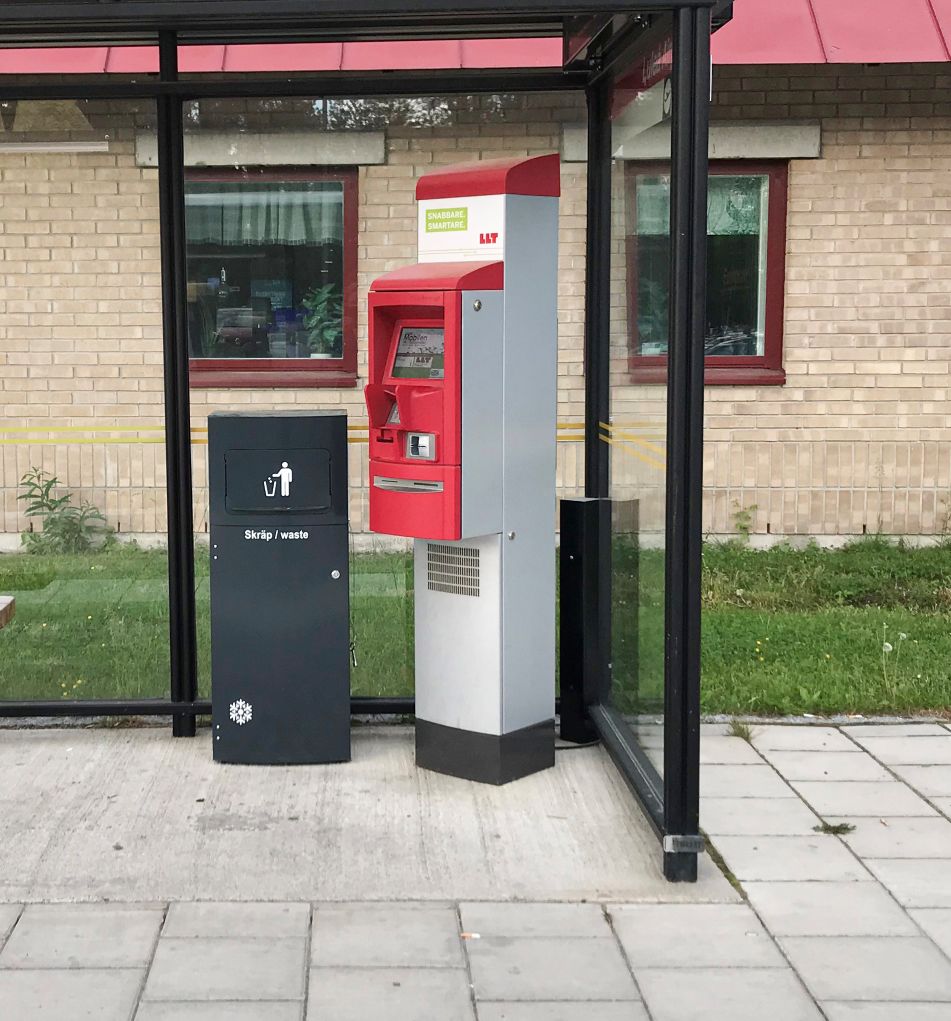Ett enskilt svart Sortify Mango kärl för skräp i ett busskurstak