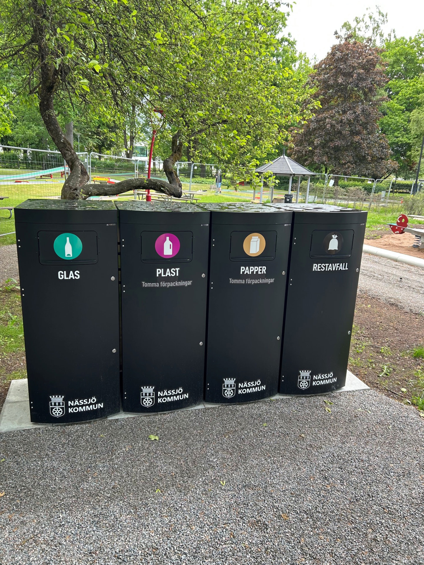 Fyra svarta Mango XL kärl med Nässjö kommuns märkning i en park
