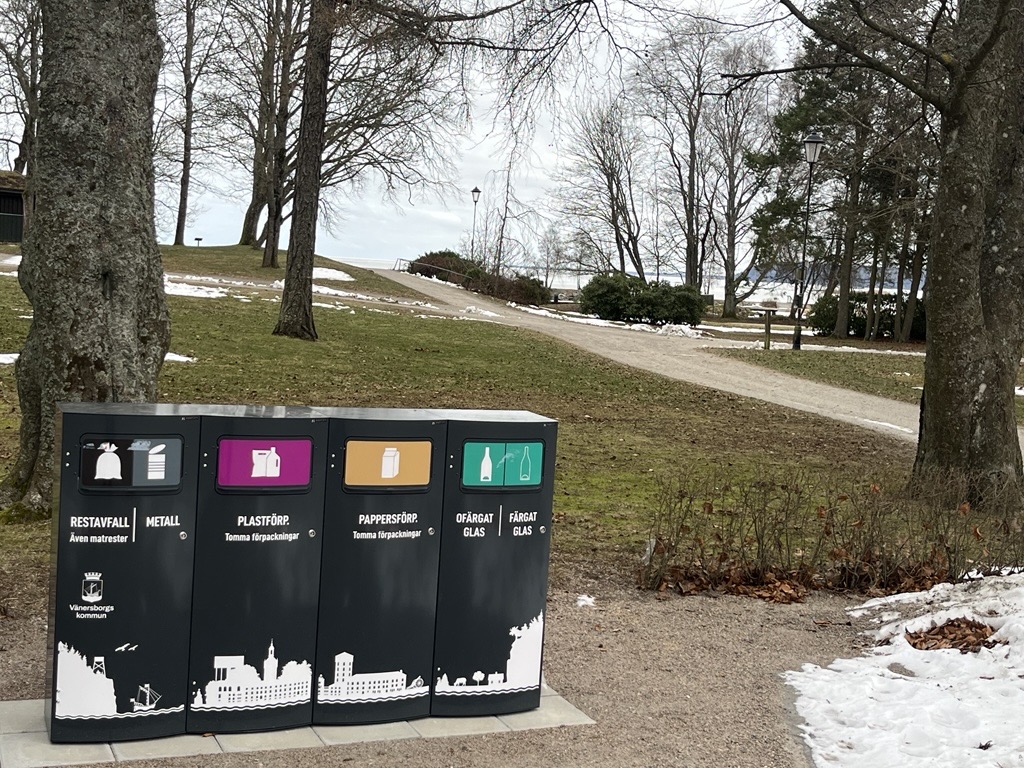 Fyra Mango M kärl med Vänersborgs stadssiluett i en parkmiljö vintertid
