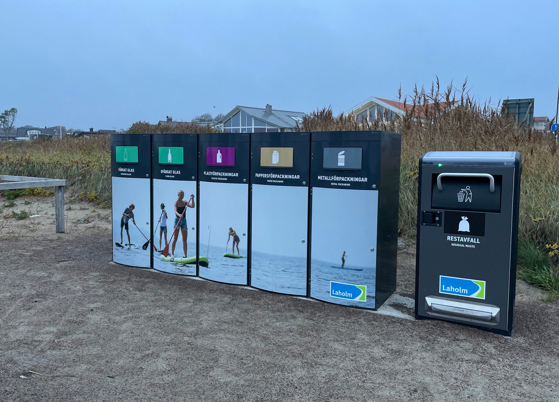 Fem Sortify Mango kärl med paddelgrafik uppställda på en strandpromenad i Laholm