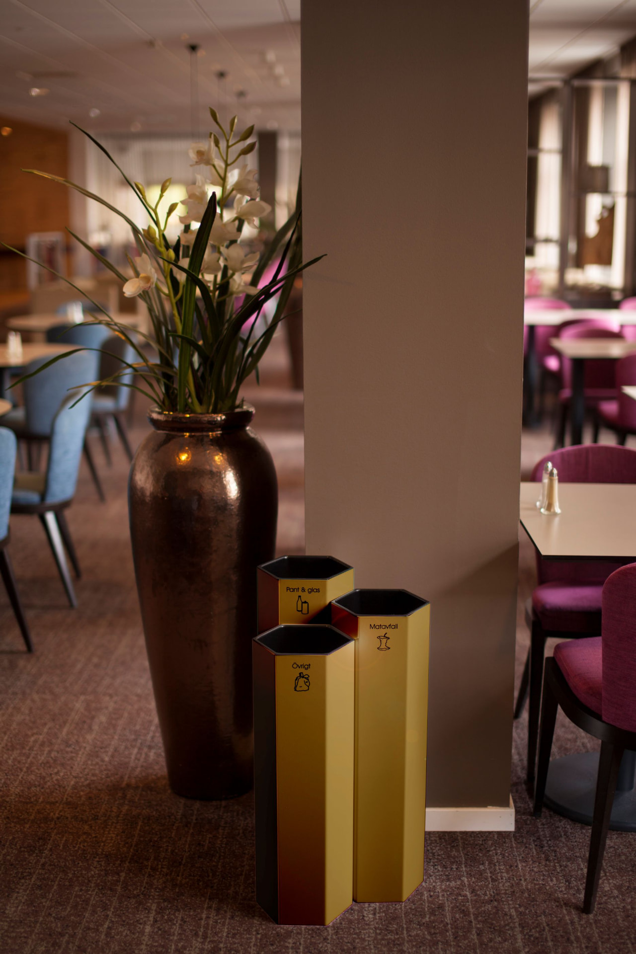 Tre guldfärgade Papaya M kärl i en restaurangmiljö