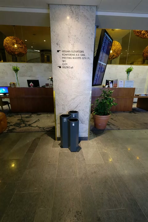 Tre Papaya-kärl framför en pelare i en hotellreception